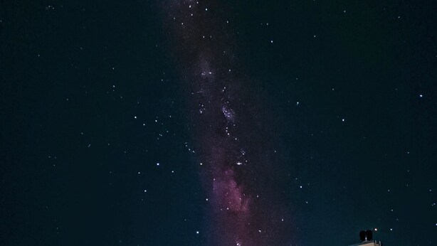 Une maison offrant une vue dégagée sur le ciel nocturne, y compris la Voie lactée.