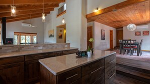 Una cocina amplia con armarios de madera, encimera de granito e iluminación colgante.