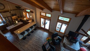 Una cocina amplia con una isla central, vigas de madera y ventanas grandes.