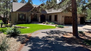 A two-story house with a stone foundation, a front porch, and a garage.