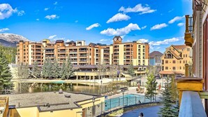 A multi-story hotel with balconies, a swimming pool, and a view of a mountain range. - Luxury 4 Bedroom Condo on Main Street in Downtown Breckenridge (Breckenridge)