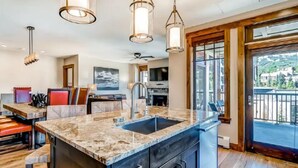 A kitchen with a granite countertop, stainless steel sink, and pendant lighting. - Luxury 4 Bedroom Condo on Main Street in Downtown Breckenridge (Breckenridge)