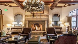 A formal lounge area with leather sofas, a fireplace, and a chandelier. - Vail Arrabelle 3 Bedroom Residence (Vail)