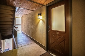 Enter room 10 through this rustic hallway with a wooden door and exposed beams.