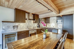 Enjoy meals in this kitchen with a dining table, stainless steel appliances, and wooden cabinets.