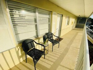 Relax on the balcony with a pair of chairs and a small table, taking in the views of the surrounding neighborhood.