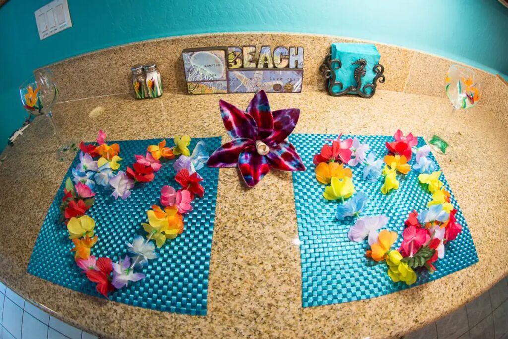 Mostrador con un letrero que dice 'BEACH', flores decorativas y un molinillo de viento.