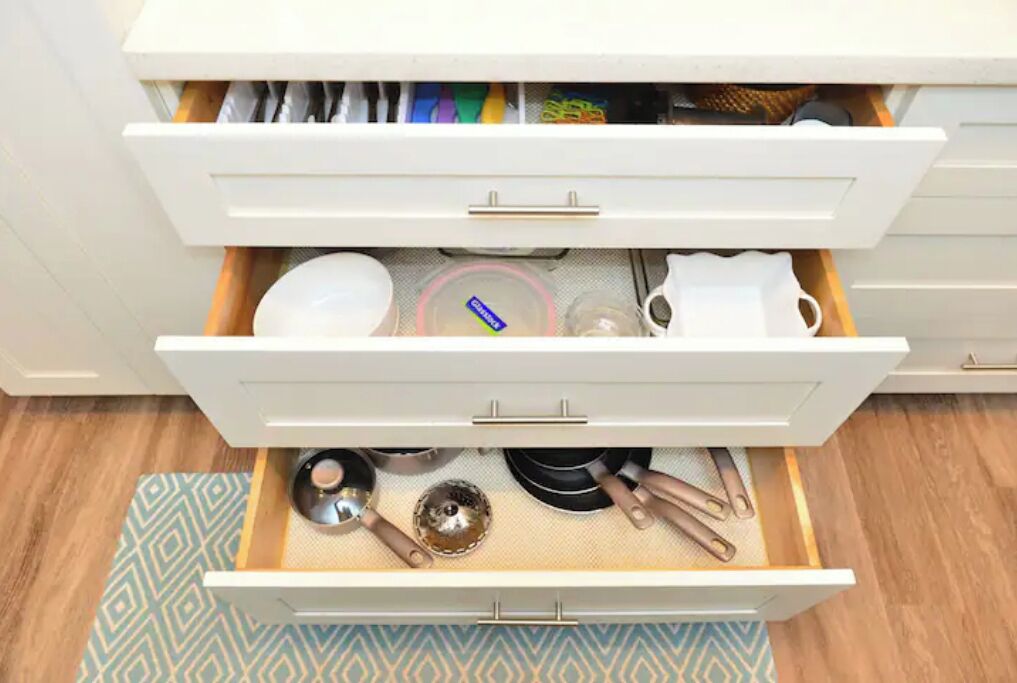 Un cajón de cocina con utensilios y utensilios de cocina.