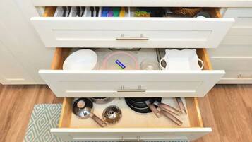 Un cajón de cocina con utensilios y utensilios de cocina.