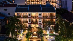 A multi-story hotel with a central courtyard, balconies, and outdoor seating areas.