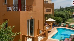 A hotel with a pool, outdoor seating, and a view of the surrounding greenery. - Hotel Elotia (Chania)