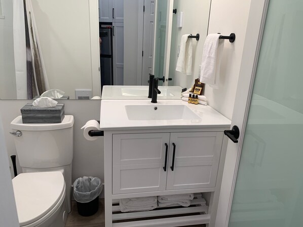 A modern bathroom with a white sink, toilet, and vanity.