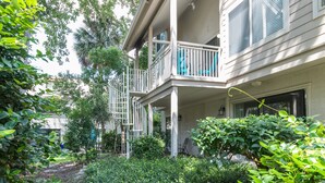 A two-story house with a balcony, surrounded by lush greenery. - Serene Courtside Villa • 2 Pools • Free Pickleball, Tennis • 5-min Walk to Beach (Hilton Head Island)