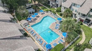 A rooftop pool with blue umbrellas, lounge chairs, and a clear blue pool. - Serene Courtside Villa • 2 Pools • Free Pickleball, Tennis • 5-min Walk to Beach (Hilton Head Island)