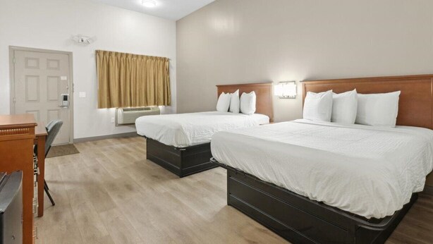 Una habitación de hotel con dos camas, un escritorio y una silla.