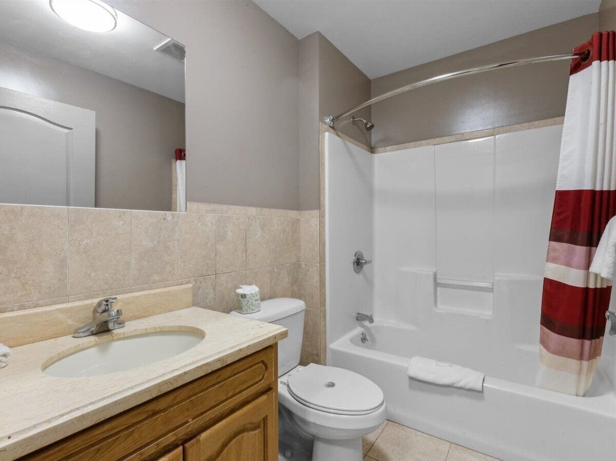 A bathroom with a sink, toilet, and shower.