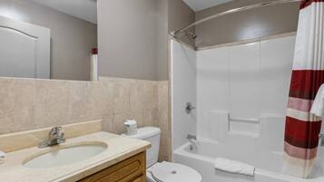 A bathroom with a sink, toilet, and shower.