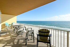Un balcon aménagé avec du mobilier d’extérieur, donnant sur l’océan.