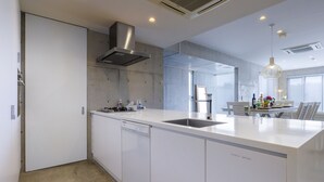 Uma cozinha moderna com armários brancos, uma pia de aço inoxidável e uma lava-louça embutida.