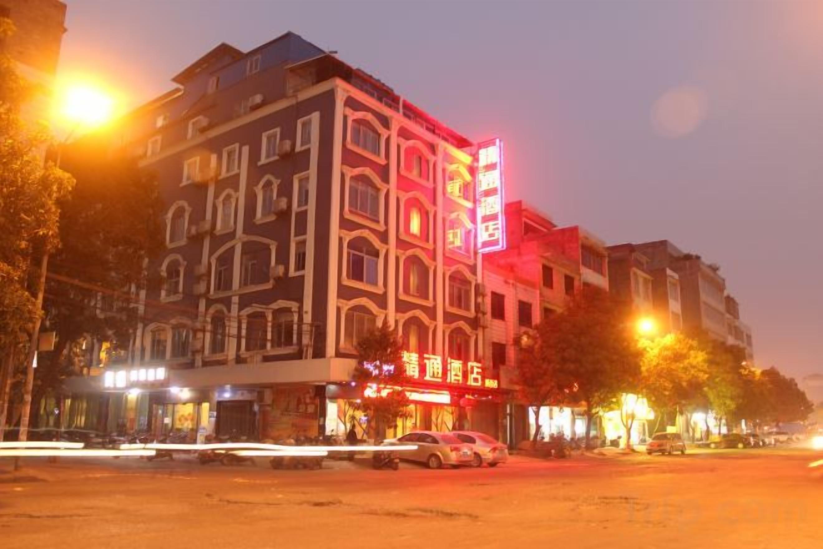 A multi-story building with a prominent sign, possibly a hotel or commercial establishment, with a flat facade and large windows.