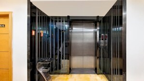 Un ascensor amb portes metàl·liques i un sòl de marbre.