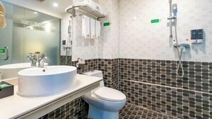 Un baño moderno con lavamanos blanco, inodoro y zona de ducha.