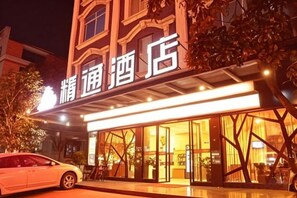 A hotel with a signboard, a car parked in front, and a well-lit entrance. - Jingtong Hotel (Yulin City West Qingwan River Park Branch) (Yulin)