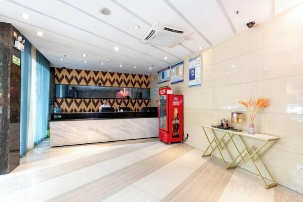 A hotel reception area with a marble counter, a red telephone, and a decorative vase. - Jingtong Hotel (Yulin City West Qingwan River Park Branch) (Yulin)