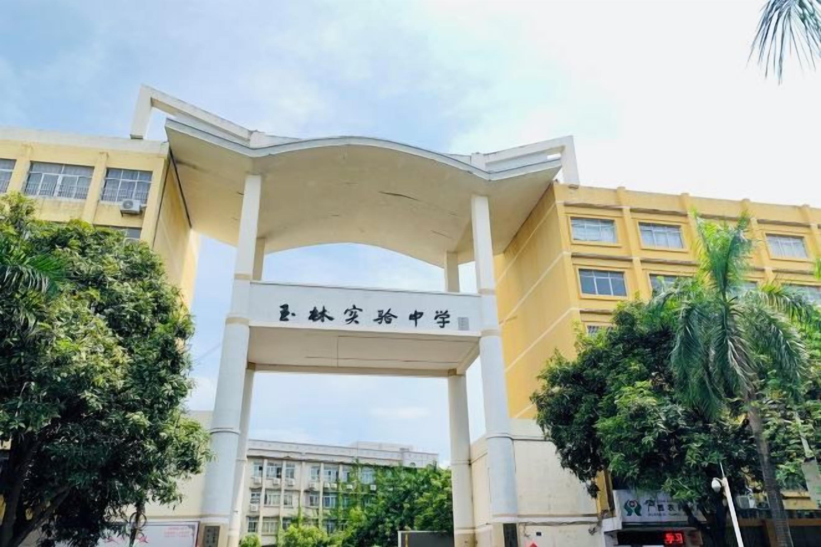 Una entrada de edificio con un gran arco y un letrero encima.
