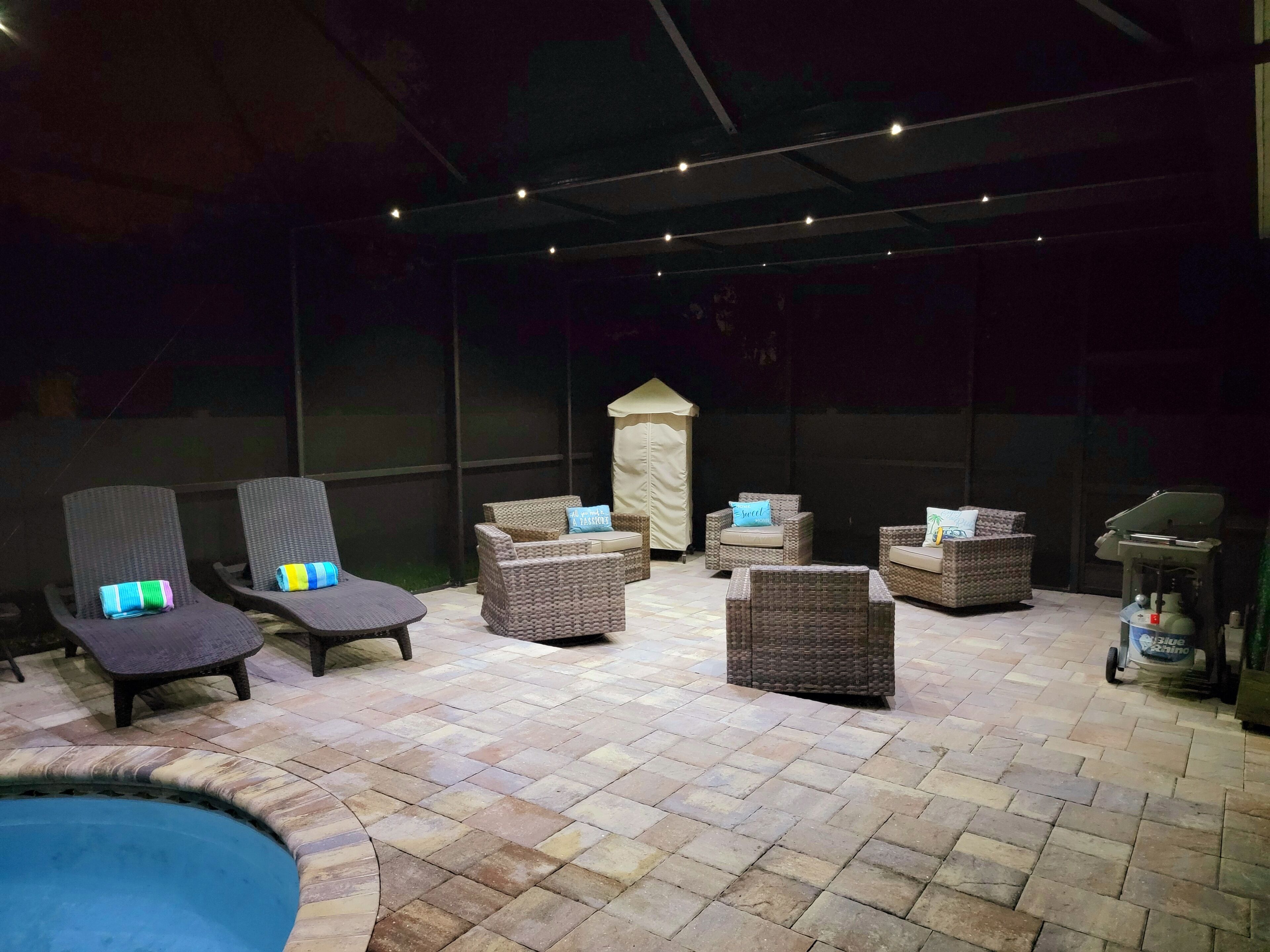 Un espace extérieur aménagé avec des meubles en osier et une petite piscine.