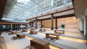 A spacious indoor area with modern seating arrangements, a glass ceiling, and a view of the outdoors. - Qiqushan Hotel (Zitong)