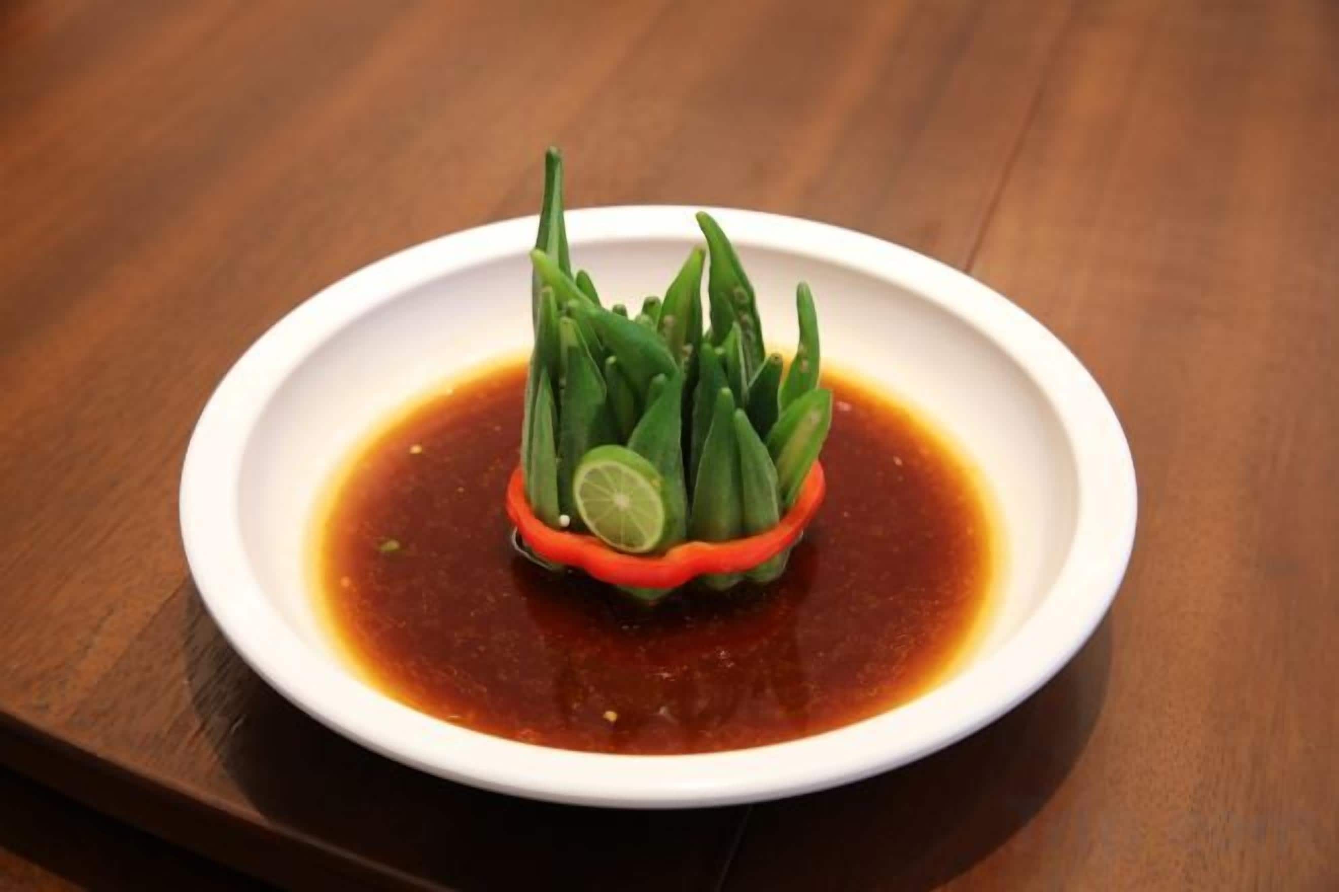 A white plate with a green vegetable garnish on a wooden table.