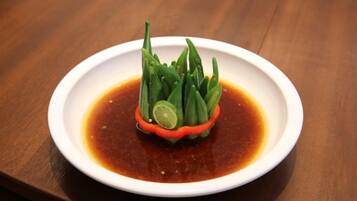 A white plate with a green vegetable garnish on a wooden table.