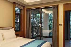 Una habitación de hotel con cama, ventana y balcón con cortinas.