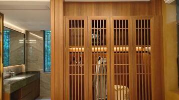 A modern bathroom with a wooden partition, a marble sink, and a mirror.