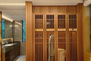 A modern bathroom with a wooden partition, a marble sink, and a mirror.