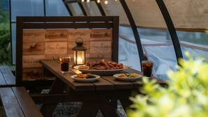 A table set with plates of food, a glass of soda, and a lit lantern. - Ganghwa Gichayeohaeng Pension (Incheon)