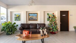 A living room with a leather sofa, a wooden coffee table, and a Christmas tree. - LOP Inn (La Asunción)