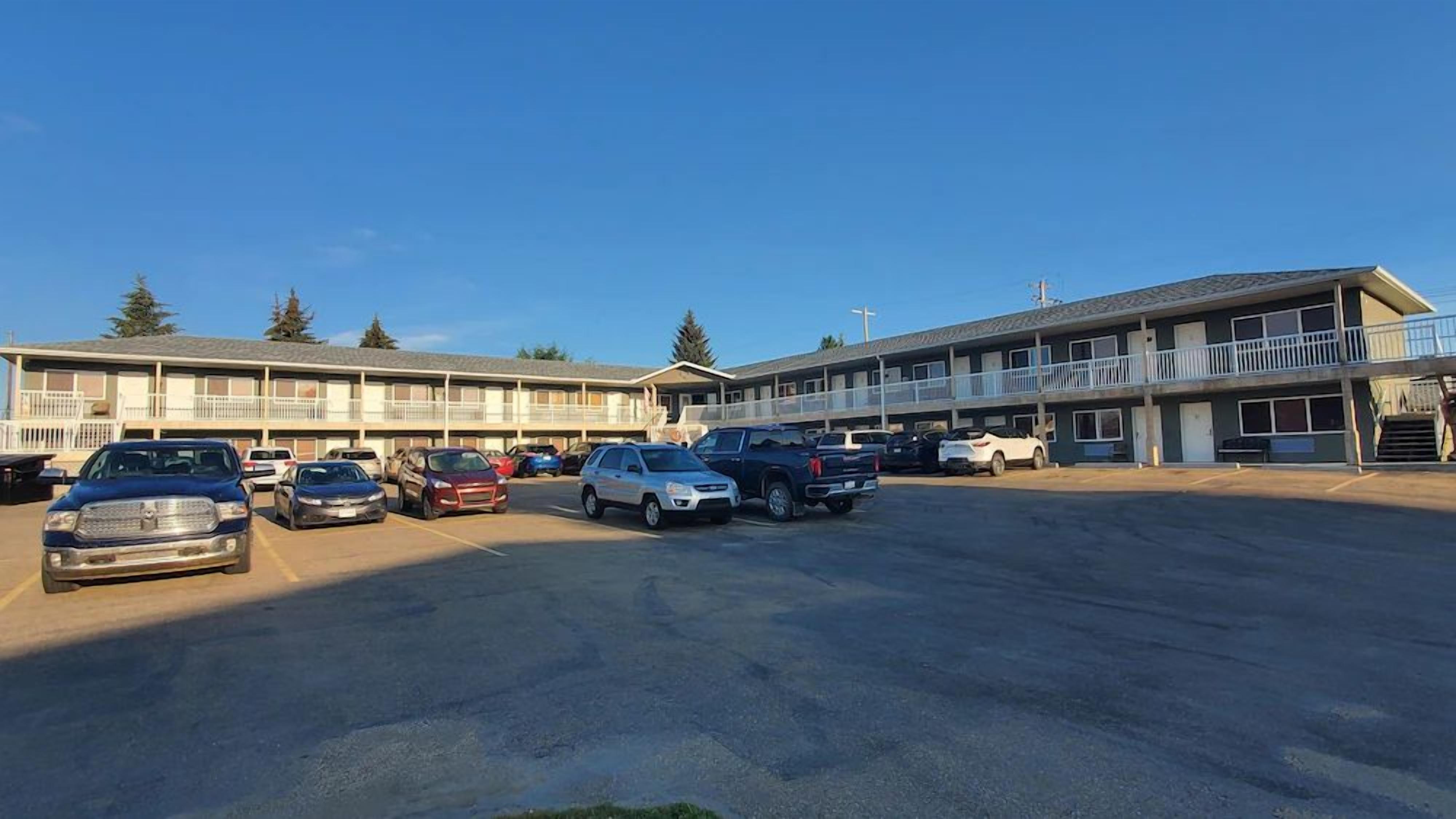 A motel with multiple parking spaces and a two-story structure.
