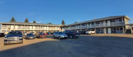 Un motel doté de nombreux espaces de stationnement et composé d’un bâtiment à deux étages.