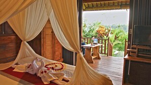 A bedroom with a canopy bed, wooden furniture, and a view of the outdoors. - Vinarya Villa (Tegallalang)