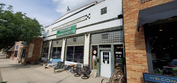 A storefront with a sign reading "Timeless Consignments" and a "Welcome" sign outside.