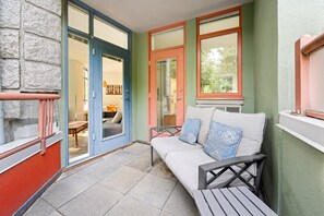 Ein Patio mit einer Couch, einem Tisch und einem Stuhl.