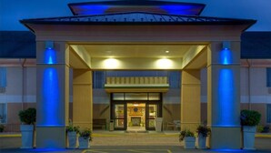A hotel entrance with a covered walkway, large pillars, and a central door. - White Pine Lodge (Salamanca)