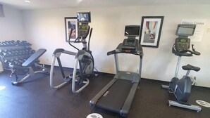 A fitness center with treadmills, elliptical machines, and a set of dumbbells. - White Pine Lodge (Salamanca)