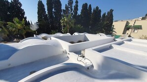 A white, curved architectural structure with a metal railing.