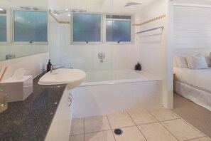 A modern bathroom with a sink, bathtub, and shower.