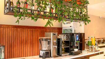 A modern kitchen with a marble countertop, built-in appliances, and a hanging plant.