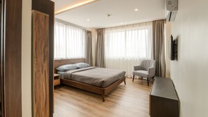 A modern hotel room with a wooden bed, a desk, and a chair. - Mila Hotel (Kathmandu)