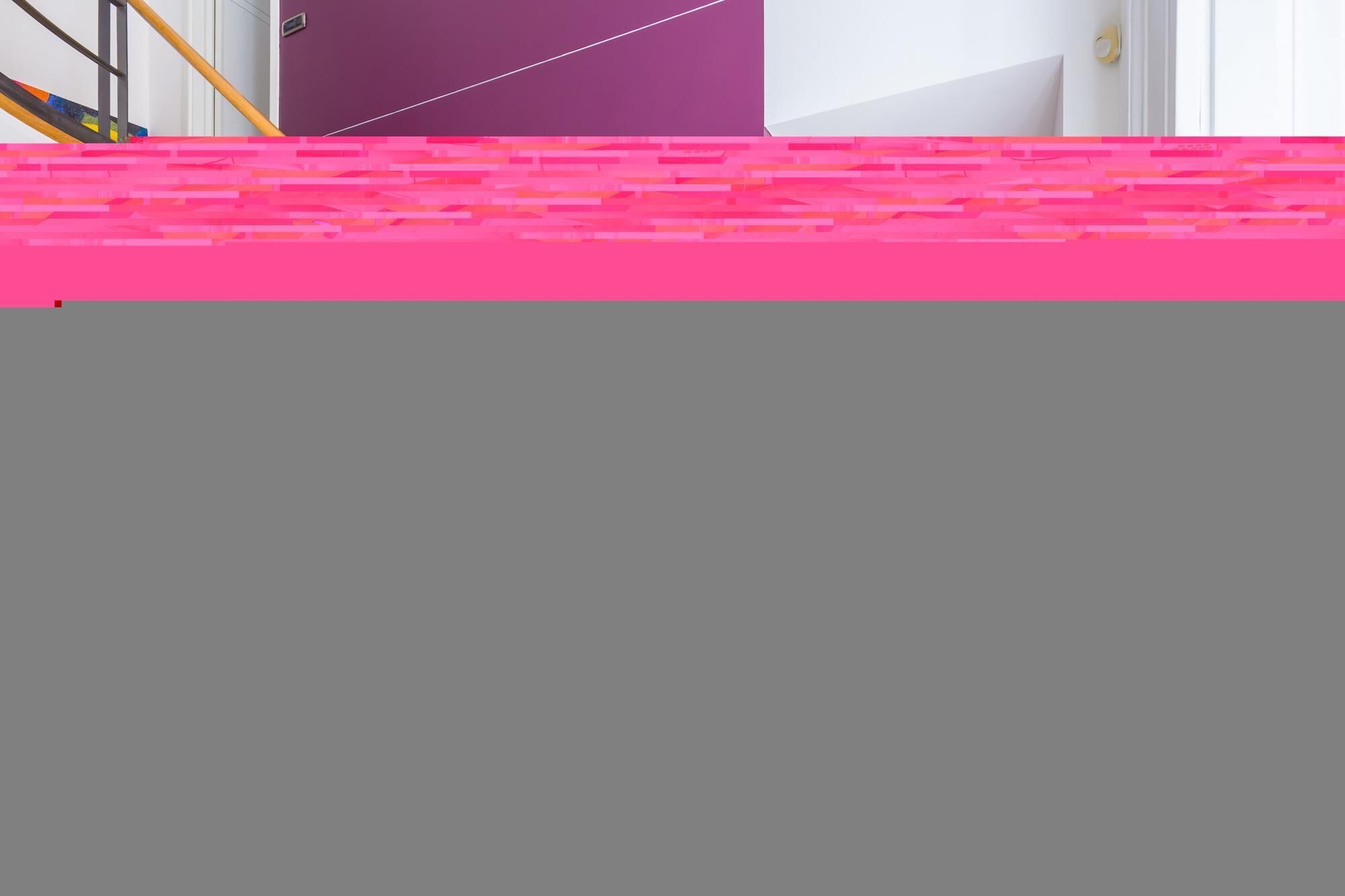 A room with a purple wall and a pink patterned area at the bottom.